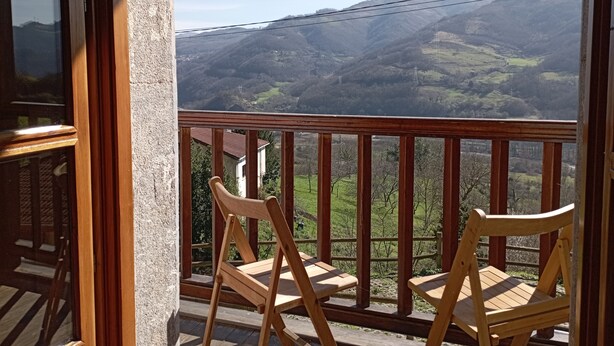 A balcony with wooden chairs and a view of a mountainous landscape. - Hotel San Martino (Lena)