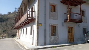 A two-story building with balconies, a sign indicating a correction, and a car parked in front. - Hotel San Martino (Lena)