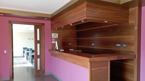 A reception desk with a wooden finish, a sign prohibiting smoking, and a computer on the counter. - Hotel San Martino (Lena)