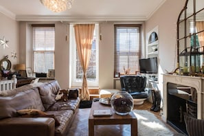 Relax in this stylish living room with a leather sofa, coffee table, and fireplace.