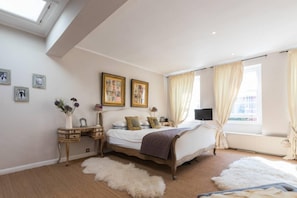 Relax in a classic bedroom with a large bed, bedside tables, and a skylight.