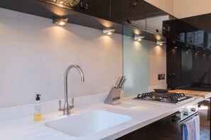 Enjoy cooking in this kitchen with a gas stove, stainless steel faucet, and large countertop.