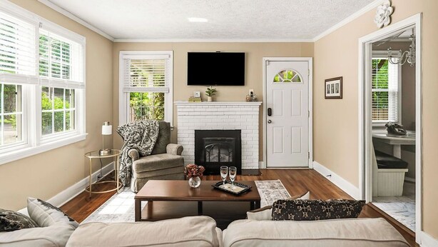 A living room with a fireplace, a television, and a door leading to a bathroom.