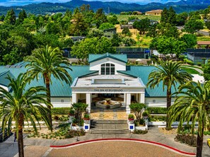A spa building with a green roof, surrounded by palm trees and a landscaped garden.