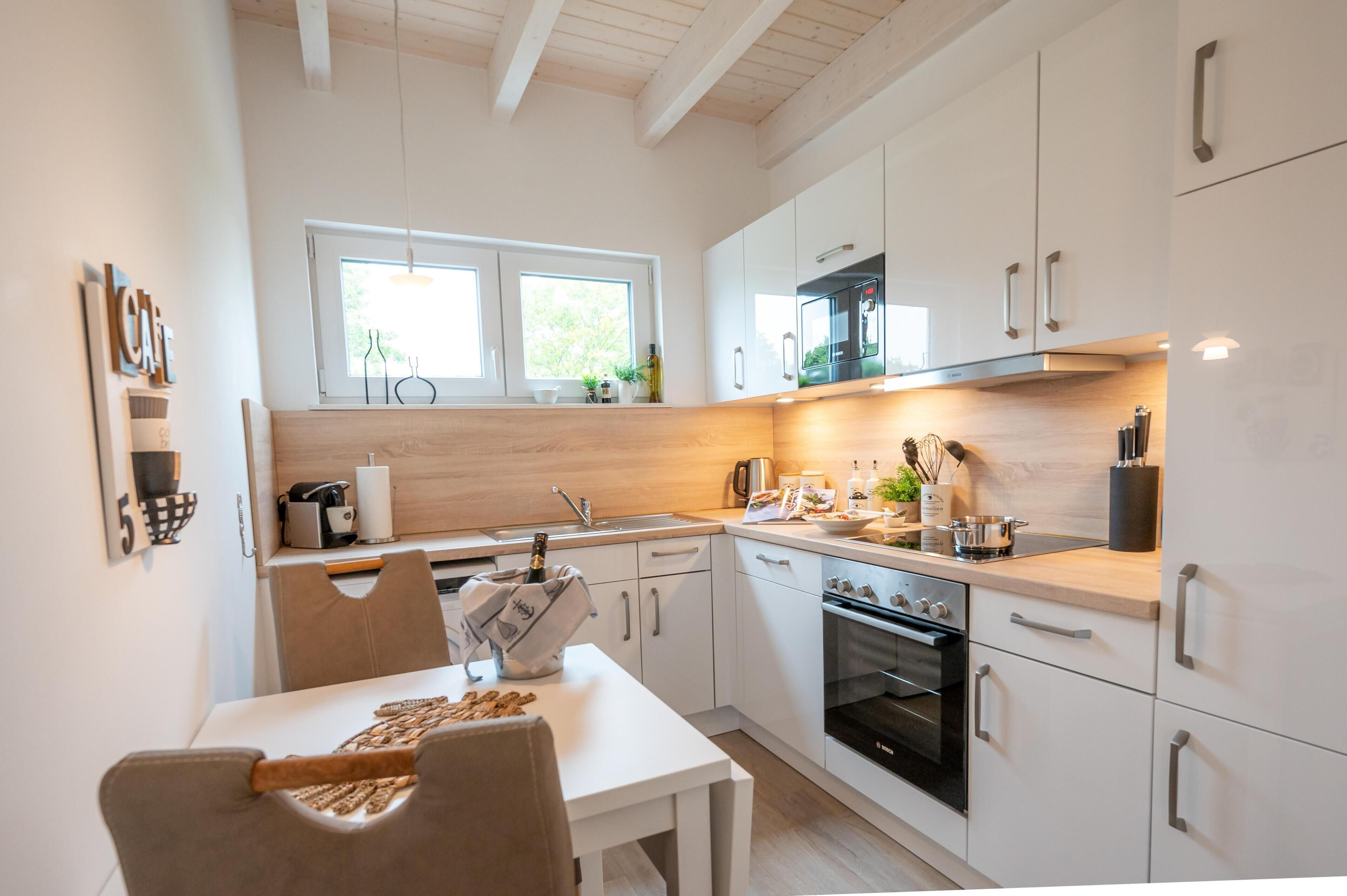 A modern kitchen with white cabinets, a wooden countertop, and a built-in oven.