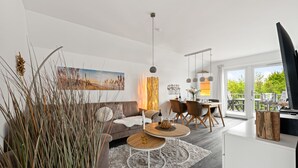 Un salon moderne avec un canapé, une table basse et un coin repas.