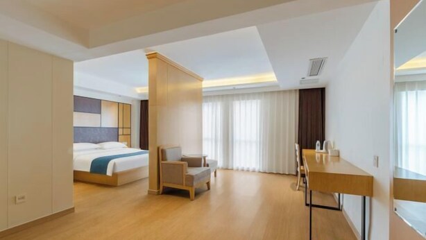 A hotel room with a bed, a desk, a chair, and a large window. - Home Inn UP Huayi Collection (Lu'an Railway Station Branch) (Lu'an)