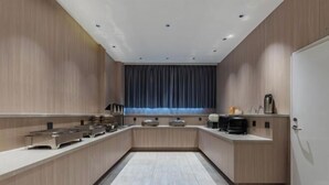 A modern kitchen with a long counter, built-in appliances, and a window with curtains. - Home Inn UP Huayi Collection (Lu'an Railway Station Branch) (Lu'an)