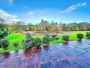 A garden with a picnic table and a paved walkway. - 4 beautiful stone barns SlEEPS 17 People (Monmouthshire)