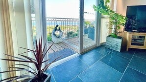 A balcony with a view of the landscape, a potted plant, and a television on a wooden stand. - Sea Views, Hot tub, Balcony, 4 star Visit Wales (Pendine Camartheshire)