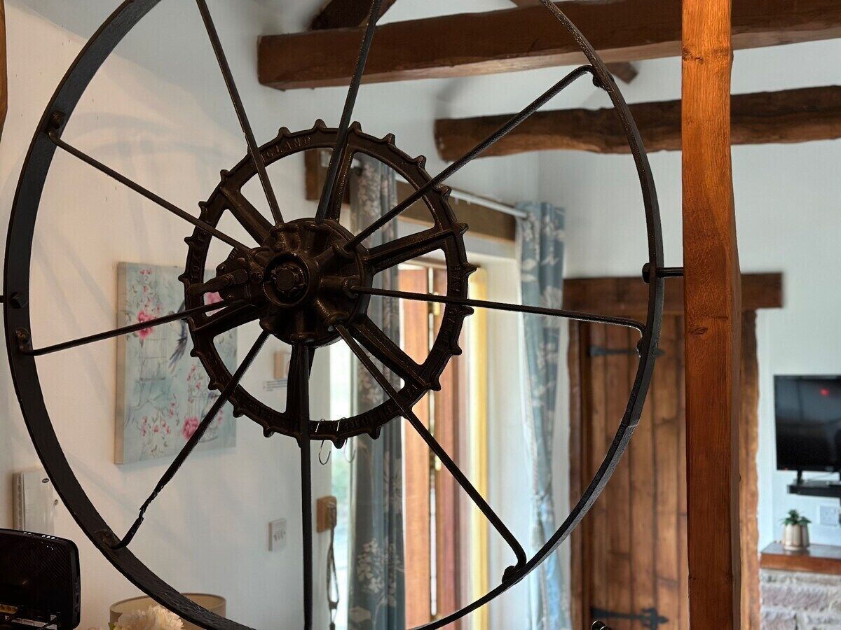 A large, rustic wooden beam structure with a metal wheel mechanism.