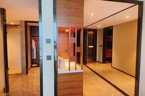 A modern hotel corridor with a wooden floor, a glass partition, and a red suitcase visible in the background. - Rong Qiao Hotel (Fuzhou)