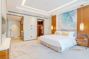 A modern hotel room with a large bed, a walk-in closet, a painting on the wall, and a bedside table with a lamp. - Rong Qiao Hotel (Fuzhou)