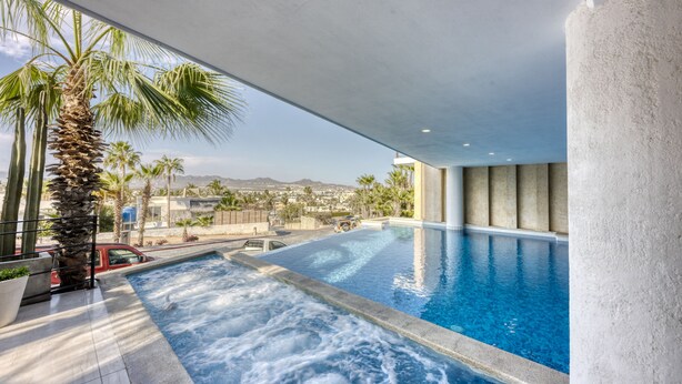 Una piscina interior moderna con vistas a la ciudad y las montañas.