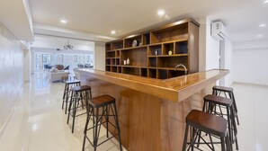 Una cocina moderna con una isla de madera, taburetes de bar y estantes empotrados.