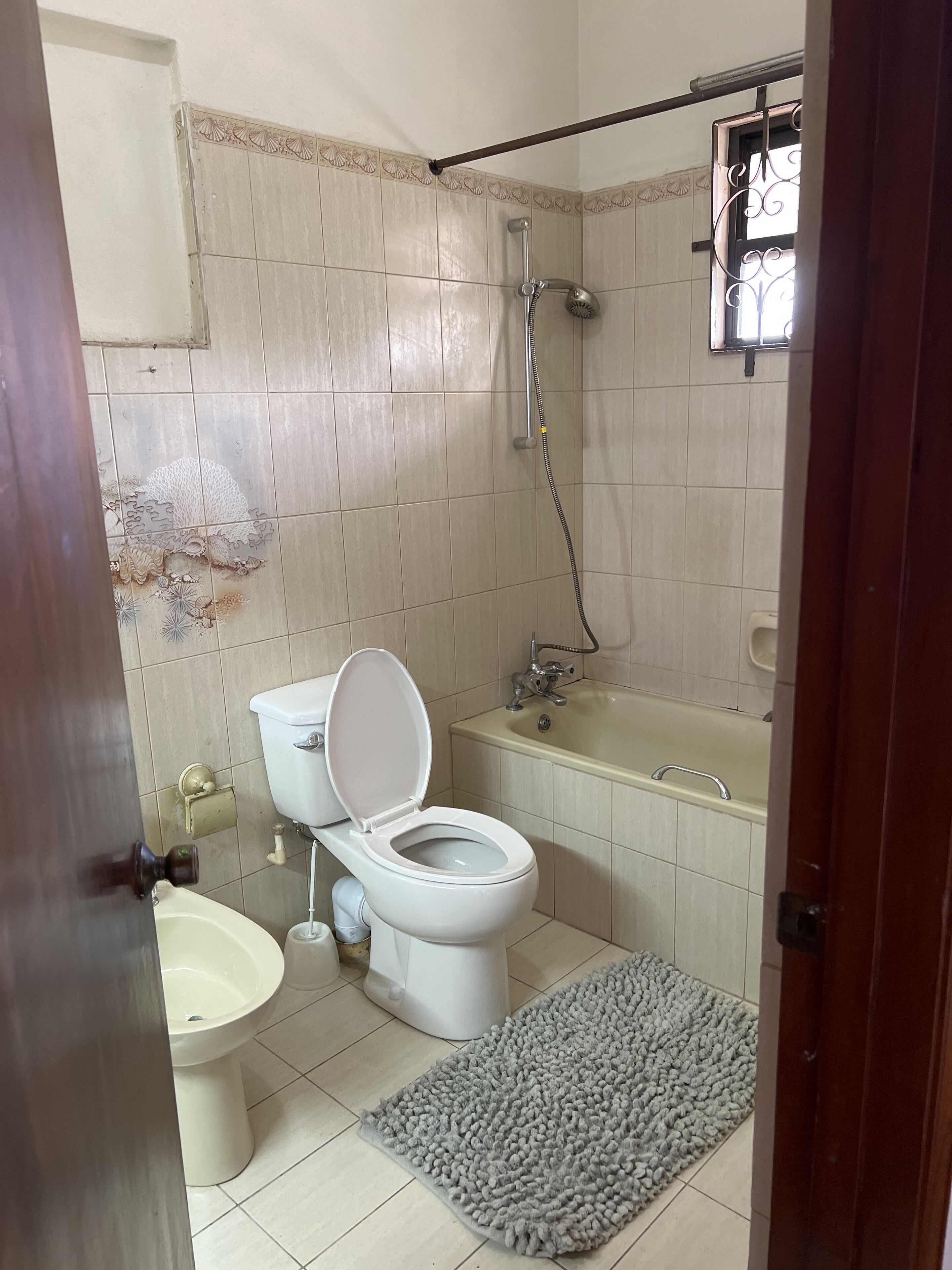 A bathroom with a toilet, bidet, bathtub, and shower.