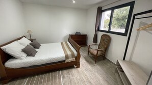 A bedroom with a wooden bed, a chair, a nightstand, a dresser, and a window with curtains. - U SECONDU - Quiet, spacious new apartment (ALERIA)