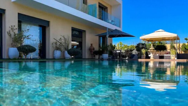 Un bâtiment moderne à deux étages, avec une piscine à eau claire située devant.