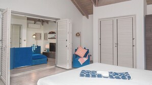 Une chambre à coucher avec un lit, un canapé bleu, une chaise et une armoire.