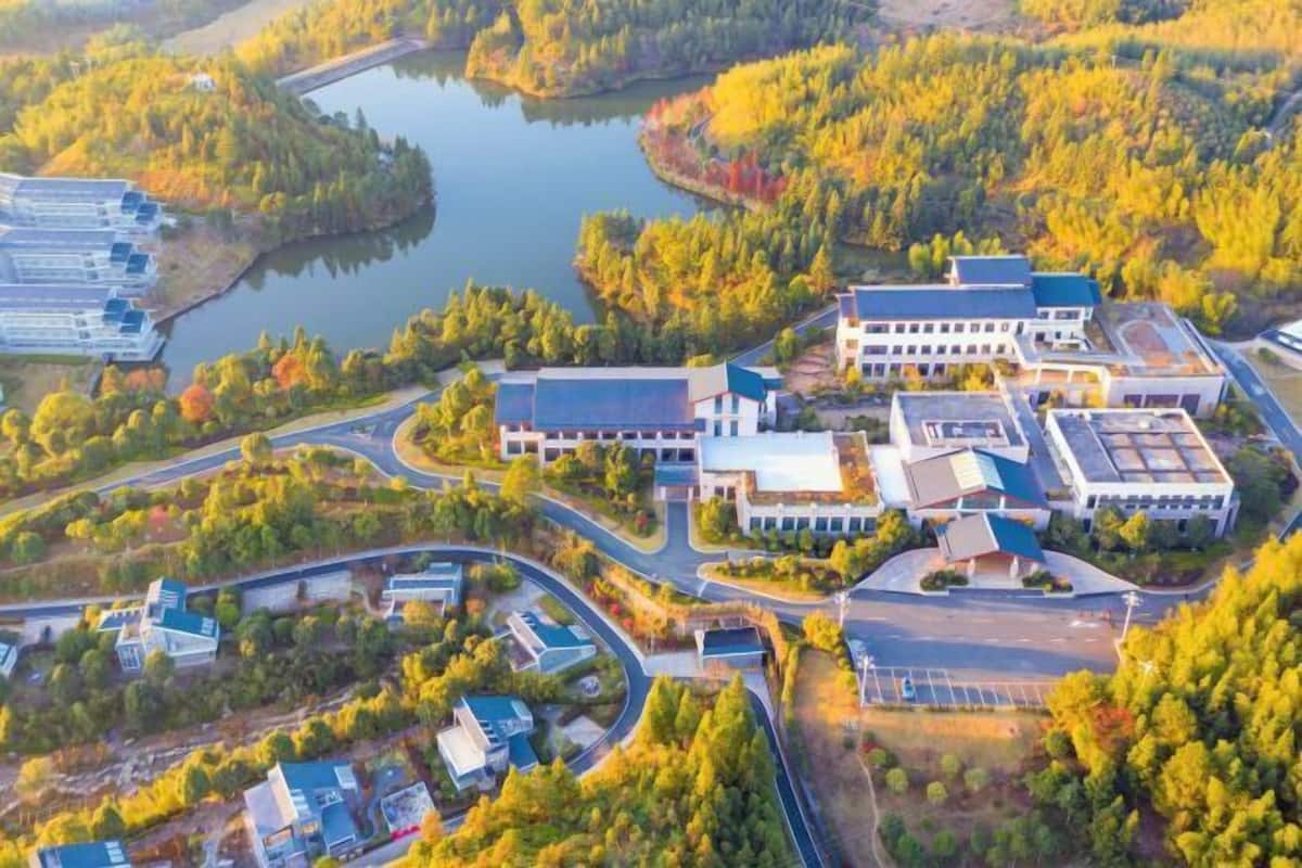 Oversigtsbillede af et campus med flere bygninger, veje og en sø.
