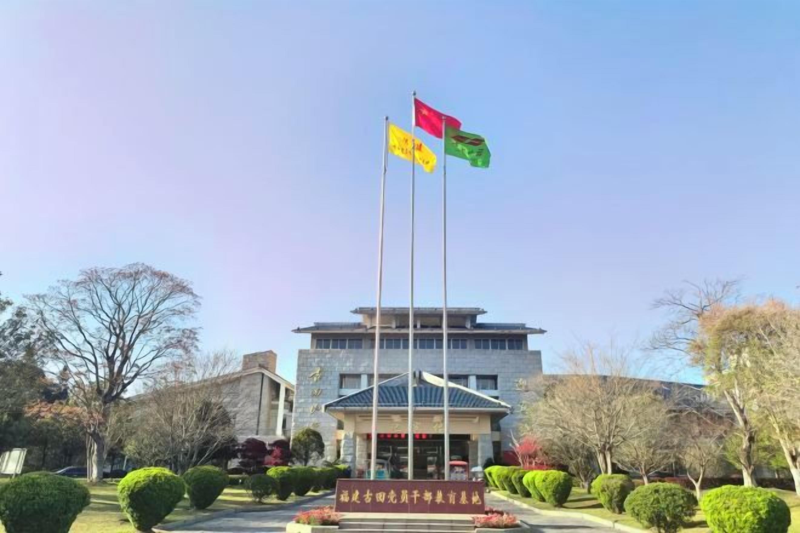 A building with a flagpole, a flag, and a sign.