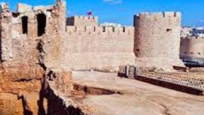 A coastal fortification with stone walls and towers, overlooking a body of water and a cityscape in the background. - Cozy studio with balcony (Marrakesh)