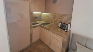 A compact kitchen with a sink, countertop, and a coffee maker. - Cozy studio with balcony (Marrakesh)
