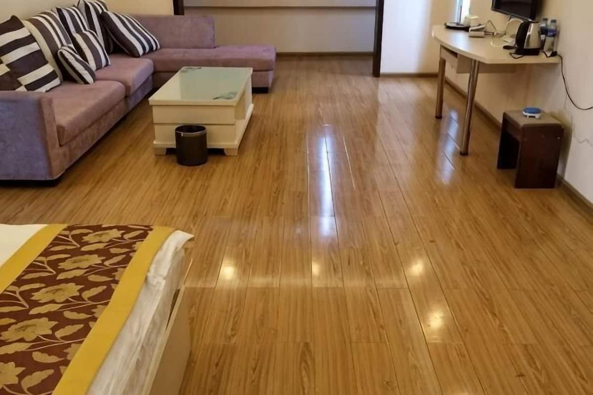 Una habitación con cama, sofá, mesa de centro, televisor y escritorio con computadora.