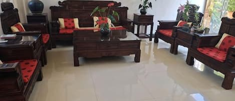 Un salón tradicional con un sofá, una mesa de centro y una alfombra roja.