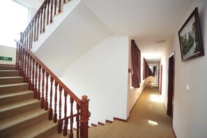 A staircase with wooden railings leading to a landing. - Youjia Inn (Shilin)