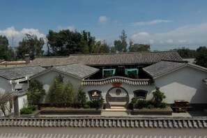 A traditional building with a tiled roof, a central courtyard, and a small garden area. - Youjia Inn (Shilin)