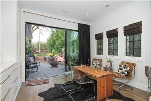 Relax in this inviting room with a sliding glass door leading to a patio area featuring outdoor seating and a fire pit.