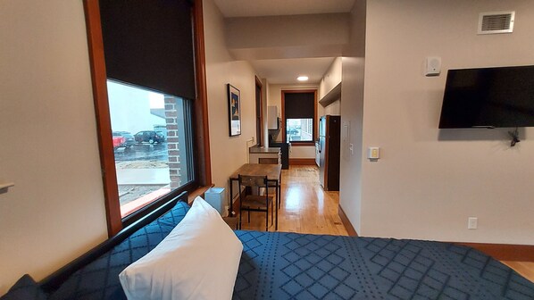 Una habitació d'hotel amb un llit, un escriptori i una televisió.