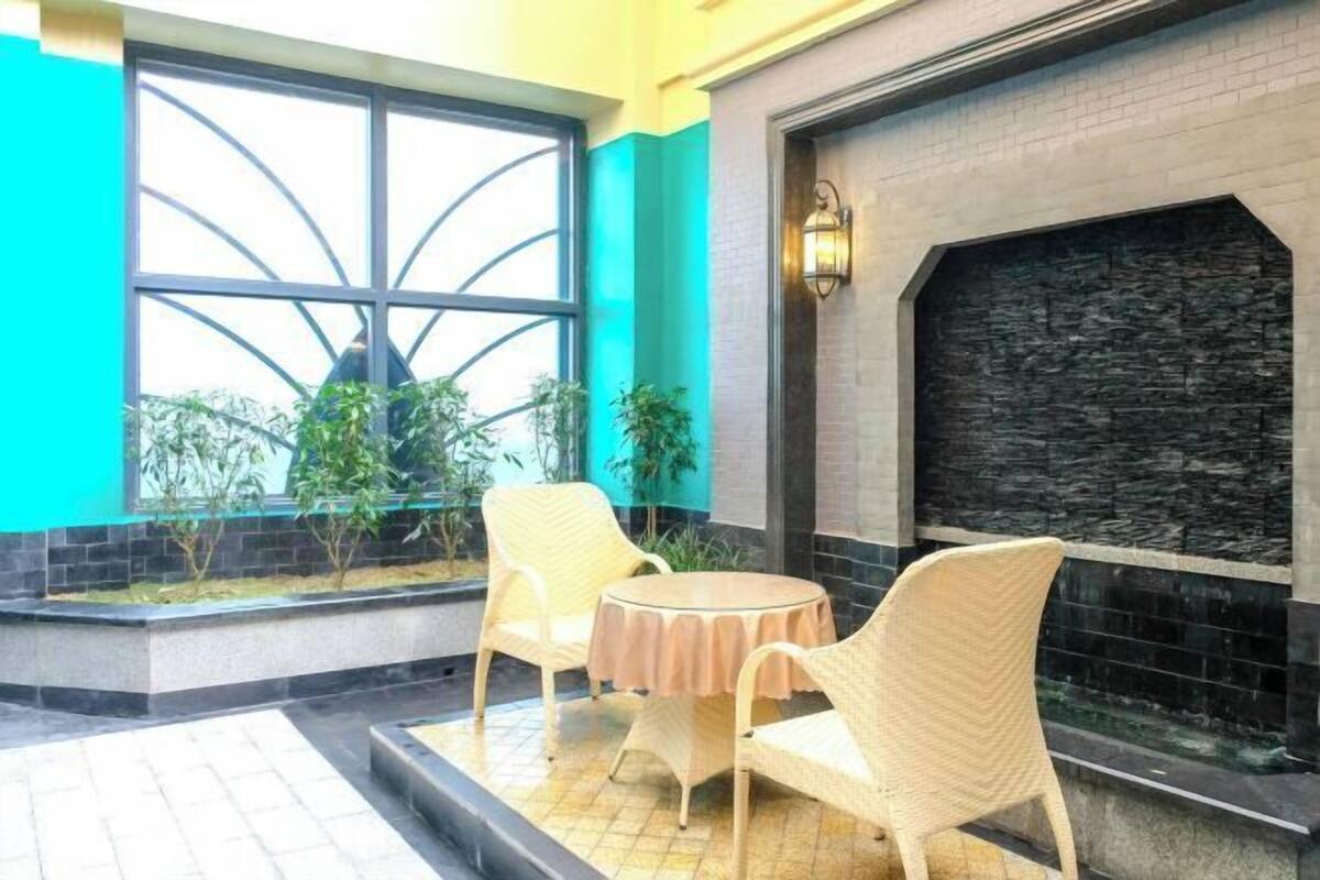 Una habitación con chimenea, una ventana de diseño peculiar y muebles de mimbre.