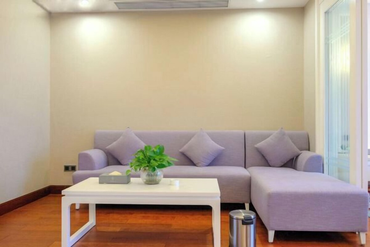 Un salon avec un canapé, une table basse et une plante.
