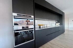 A modern kitchen with built-in appliances, a view of mountains, and a minimalist design. - Modern House Apartment 4, Menaggio, Italy (Menaggio)