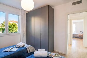 A bedroom with a bed, a wardrobe, a window, and a door leading to another room. - Modern House Apartment 4, Menaggio, Italy (Menaggio)