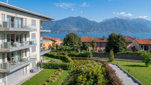 Un bâtiment moderne doté de balcons donnant sur un paysage montagneux et un plan d’eau.