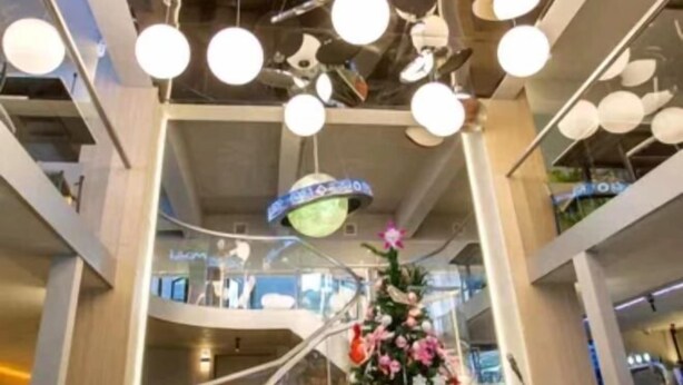 A modern interior with a central spiral staircase, multiple levels, and hanging spherical lights. - sinweier hotel (Mianyang)