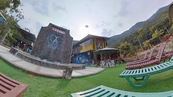 A park area with a stone sign reading "SOROMA," green lounge chairs, and a building with a mural.