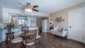 A spacious living area with a dining table and chairs, a sofa, and a ceiling fan. - Cozy 2 Bed 2 Bath Waterfront Condo SE Cape Coral only 20 min to Ft Myers Beach (Cape Coral)