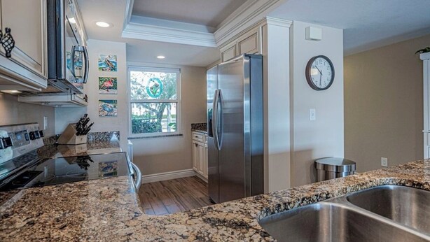 A modern kitchen with granite countertops, stainless steel appliances, and a window providing natural light. - Cozy 2 Bed 2 Bath Waterfront Condo SE Cape Coral only 20 min to Ft Myers Beach (Cape Coral)