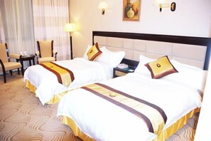 A hotel room with two beds, a nightstand, a chair, and a lamp. - Hexie Hotel (Zhenxiong)