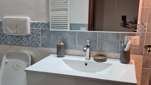 A bathroom with a white sink, a mirror, and a toilet. - Pretty apartment in the center of Vasanello (VT), close to all services (Vasanello)