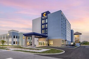 A Comfort Inn & Suites hotel with a modern design, featuring a prominent sign, a covered entrance, and a landscaped front yard.