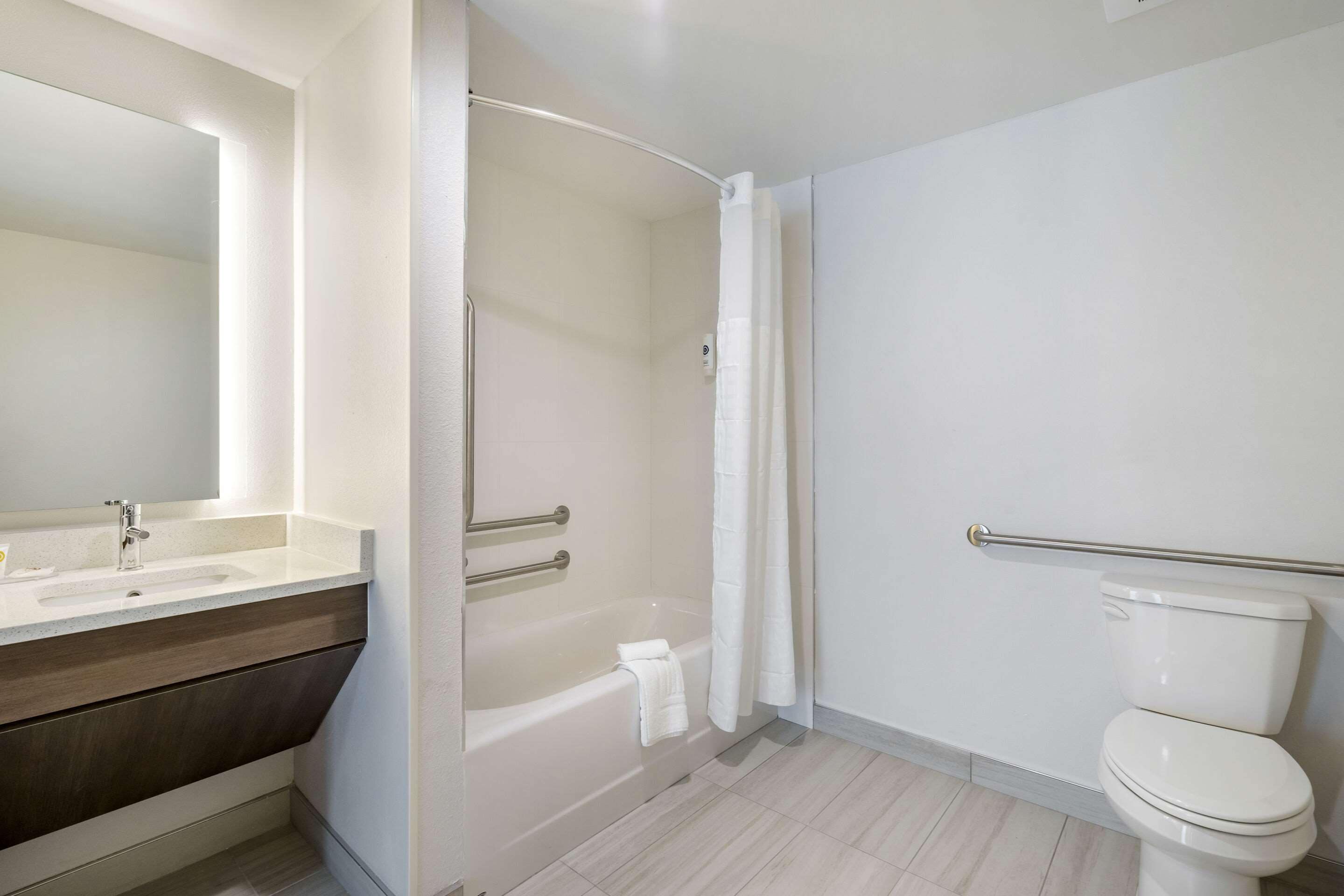 Un baño moderno con bañera, inodoro y tocador.
