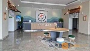 A reception area with a counter, a logo, and a seating area with stools. - Serpong Garden Apartment by Kakarama (Cisauk)