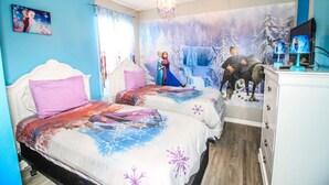 A bedroom with two beds, a dresser, and a TV. - 8 Bedroom home with pool, spa & games room near Disney (Kissimmee)