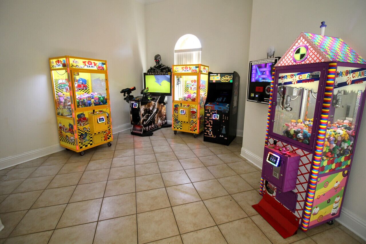 A room with arcade machines, a TV, and a window.