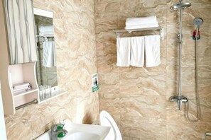 A bathroom with a sink, mirror, towel rack, and shower. - Jinxiang Hotel (Zhangjiajie)